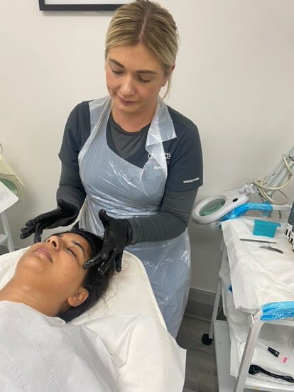 Sammie giving a client a facial